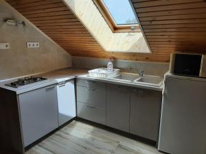 a kitchen with a stove and a sink and a window at 11 féröhelyes apartman in Balatonlelle