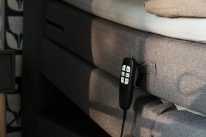 a remote control sitting on the side of a bed at Ferienwohnung am See "Flora" in Bad Zwischenahn +8 photos