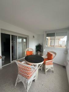 a living room with a table and chairs at El buen sol de la manga in La Manga del Mar Menor