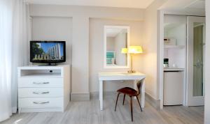 a room with a desk with a television and a mirror at The Wave Hotel Condado in San Juan