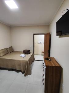 a room with two beds and a television in it at Pousada Pai&Filho in Piranhas