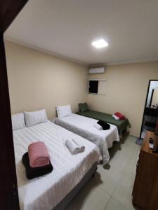 two beds in a hotel room with towels on them at Pousada Pai&Filho in Piranhas +6 photos