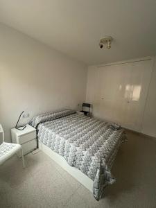 a bedroom with a bed and a lamp on a night stand at El buen sol de la manga in La Manga del Mar Menor +42 photos
