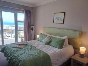 a bedroom with a bed with a view of the ocean at Stone Crown Manor B&B in Mossel Bay