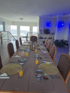 a long wooden table with plates and glasses on it at Stone Crown Manor B&B in Diasstrand