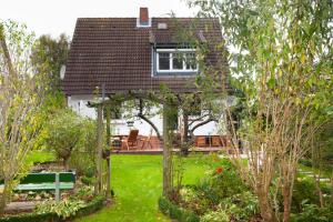 Un jardín con un cenador delante de una casa. en Carpe Diem Dahme, en Dahme