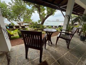 a patio with a table and chairs and the ocean at Sun N Sea Hotel in Unawatuna