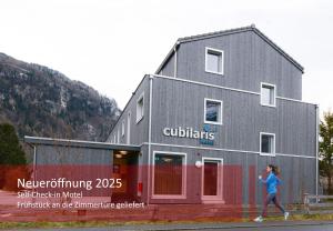 eine Frau, die vor einem Gebäude geht in der Unterkunft Cubilaris Motel in Bad Ragaz