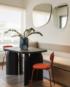 a table and two chairs in a room with a mirror at 2BR Cozy City View CBD Sudirman Park Apartment, Luxury & Chic Design in Jakarta