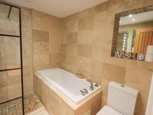 un bagno con vasca e WC di Workshop Cottage a Bowness-on-Windermere Altre 22 foto