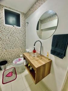 a bathroom with a sink and a mirror and a toilet at Casa em Condomínio em Mangaratiba in Mangaratiba