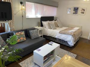 a living room with a couch and a bed at Poole Park House in Poole +93 photos