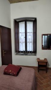 a bedroom with a bed and a window with curtains at Casa vacanze la torre in Umbertide +5 photos