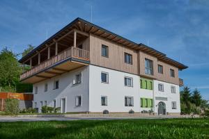 福尔希多夫Laudach INN的一座白色的大建筑,设有木屋顶
