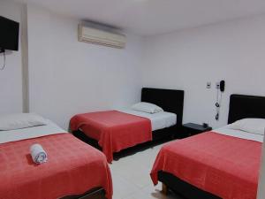 库库塔Hotel Montecarlo Suite的一间设有两张红色床单的床的房间