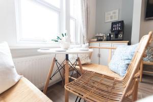 a living room with a table and chairs and a window at Poole Park House in Poole