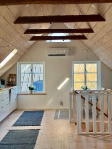 an attic kitchen with a staircase and two windows at Arnhög Farm in Borrby +73 photos