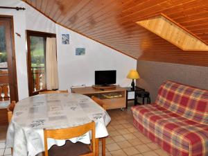 Pokój ze stołem, kanapą i telewizorem w obiekcie Appartement cosy au cœur du village, avec balcon, acceptant animaux - Idéal familles! - FR-1-692-7 w mieście La Chapelle-dʼAbondance