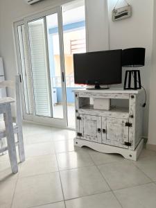 a television on a dresser in a living room at Blue Oceano in Santa Maria