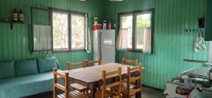 a kitchen with a wooden table and green walls at Sol de Sauce in Balneario Sauce Grande +2 photos