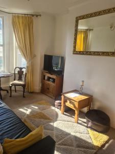 a living room with a television and a table at Spacious two bedroom flat, central location in Plymouth