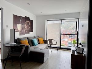 a living room with a couch and a large window at Mantu Apartment in Cusco