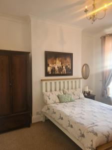 een slaapkamer met een bed en een schilderij aan de muur bij Spacious two bedroom flat, central location in Plymouth