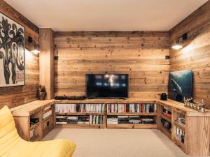 Appartement Triplex Cosy pour 6 Personnes, Centre de Val d'Isère, Proche Pistes - FR-1-567-109 في فال ديزير: غرفة معيشة مع جدران خشبية وتلفزيون بشاشة مسطحة