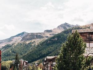 Appartement Triplex Cosy pour 6 Personnes, Centre de Val d'Isère, Proche Pistes - FR-1-567-109 في فال ديزير: منظر جبلي لمدينة فيها اشجار ومباني