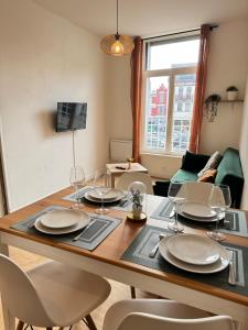 a dining room table with plates and wine glasses at Magnifique Appartement Au Cœur du Centre-Ville in Tourcoing +9 photos