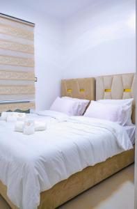 una camera da letto con un grande letto con lenzuola bianche di Perle de sable a Dakhla