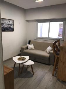 a living room with a couch and a table at Depto centro comercial Güemes shopping Aldrey 400 metros de la playa in Mar del Plata
