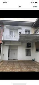 a large white building with a balcony and a courtyard at Ahnaf Guest House in Sunggal
