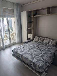 una camera da letto con un letto e una grande finestra di Dani's Lakeside Apartment in Euroresidence a Garda