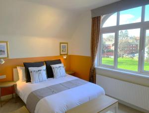 a bedroom with a bed and a large window at Melbury Rooms & Studios in Exeter