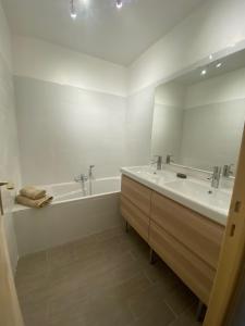 une salle de bain blanche avec une baignoire et un lavabo dans l'établissement Charmant 2 pièces parc piscine, à Vence