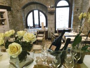 a table with flowers and wine glasses on it at Il Vicoletto in Assisi