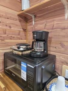una cafetera sobre un microondas en #4 - Amish Log Camping Cabin Walk to the Water cabin, en Toronto