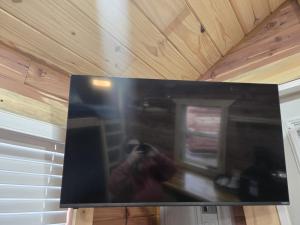 una persona tomando una foto de un televisor en una casa en #4 - Amish Log Camping Cabin Walk to the Water cabin, en Toronto 22 fotos más