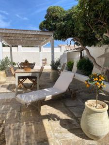 a patio with a bench and a table and a tree at Dimora Ferralasco in Carloforte