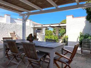 a wooden table and chairs on a patio at Dimora Ferralasco in Carloforte