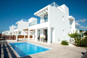 uma casa branca com uma piscina em frente em Coral Bay Villa 10 em Coral Bay