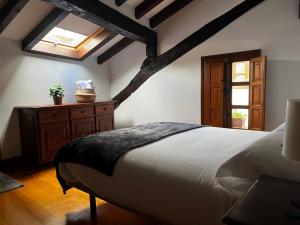 a bedroom with a bed and a dresser and a window at El Rincón de Potes in Potes