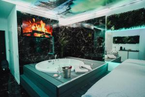 a bathroom with a bath tub and a fireplace at S O P H I A room by 50 shades in Baia Mare