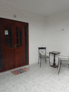 two chairs and a table next to a door at Falesias de Carapibus in Jacumã