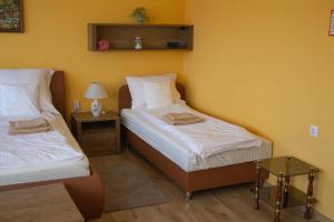 A bed or beds in a room at Sándor Apartman