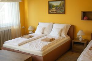 A bed or beds in a room at Sándor Apartman