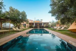 a swimming pool in front of a house at Villa Roswell Marrakech in Marrakesh