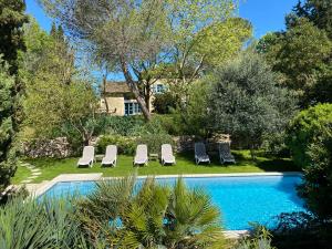 a group of lounge chairs and a swimming pool at LE CLOS PASTEL Chambres d'hôtes et son studio suite - ADULTES ONLY in Virac