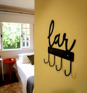 クリチバにあるConforto Studio próximo do Barigui, Gardenのベッドと「la」と書かれた看板のある部屋